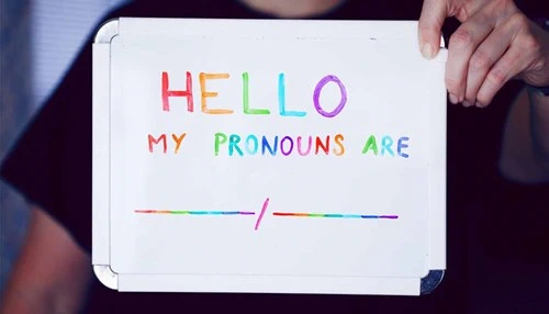 Small dry erase board with multicolored letters spelling out, "Hello my pronouns are __/__"