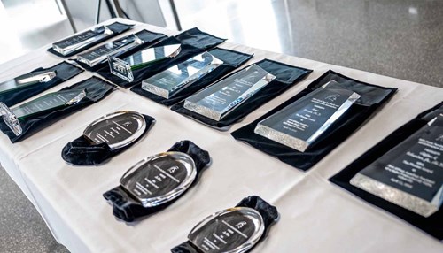 Many glass plaques are displayed on a table.